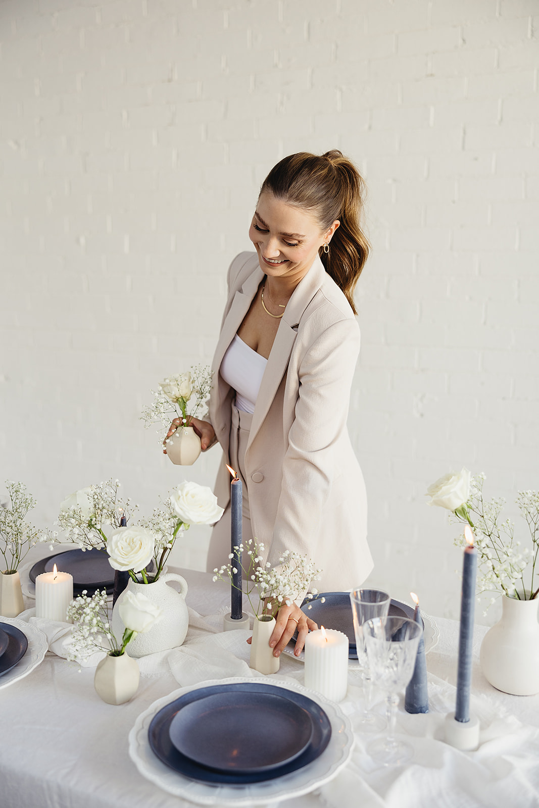 Girl in suit placing candles and plates onto a table