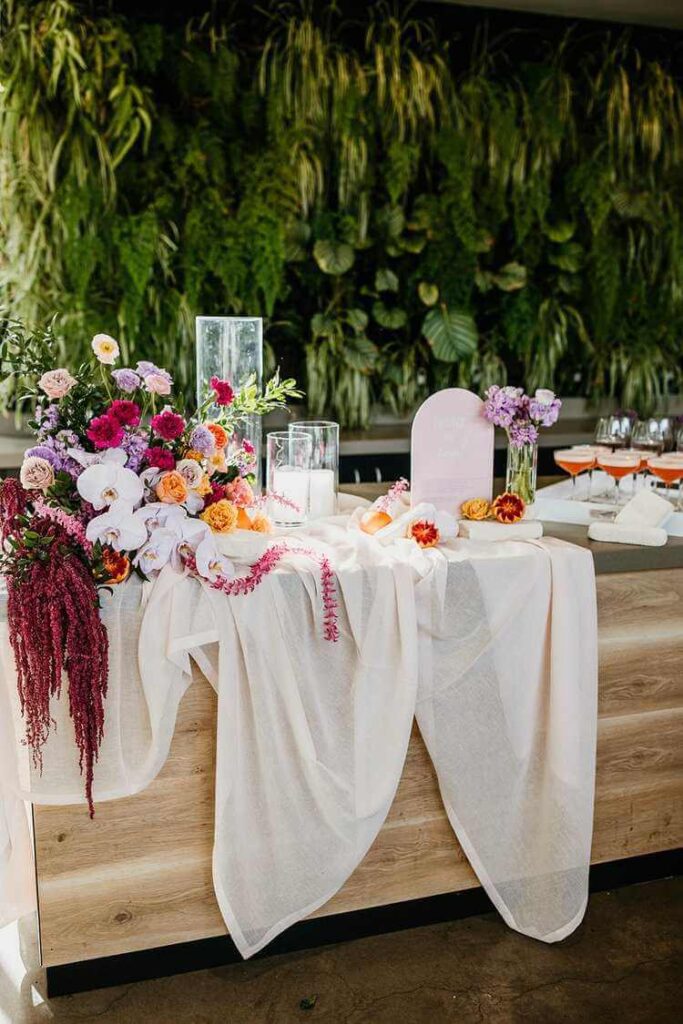 A wedding table with florals and material draped over
