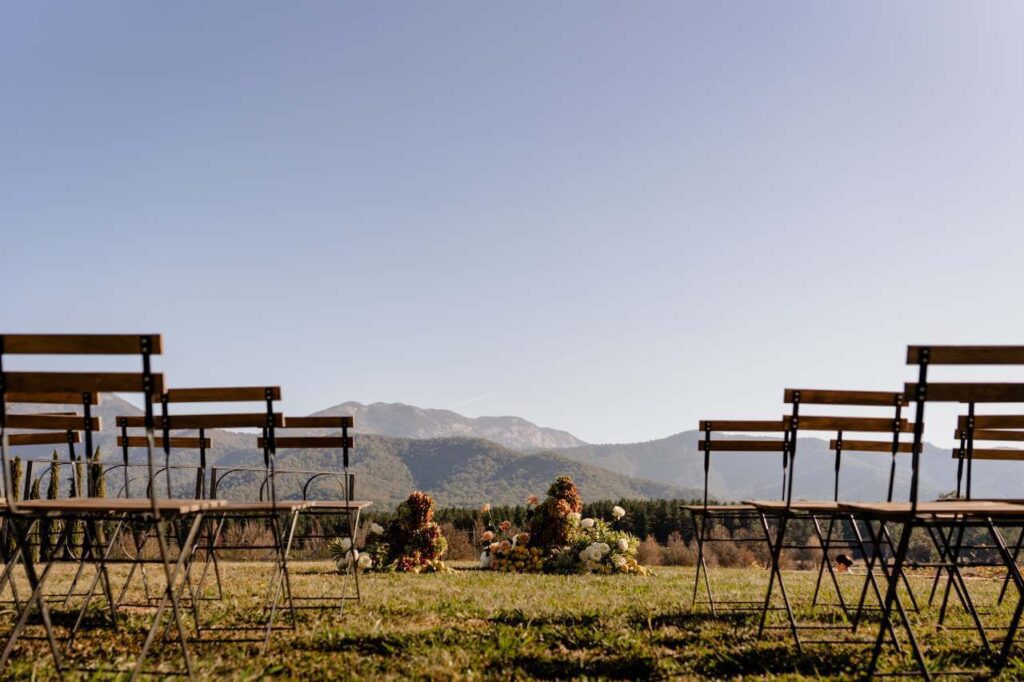 Wedding ceremony setting with flowers and chairs overlooking mountains