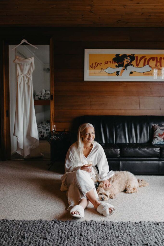 bride sitting on floor in robe with dog