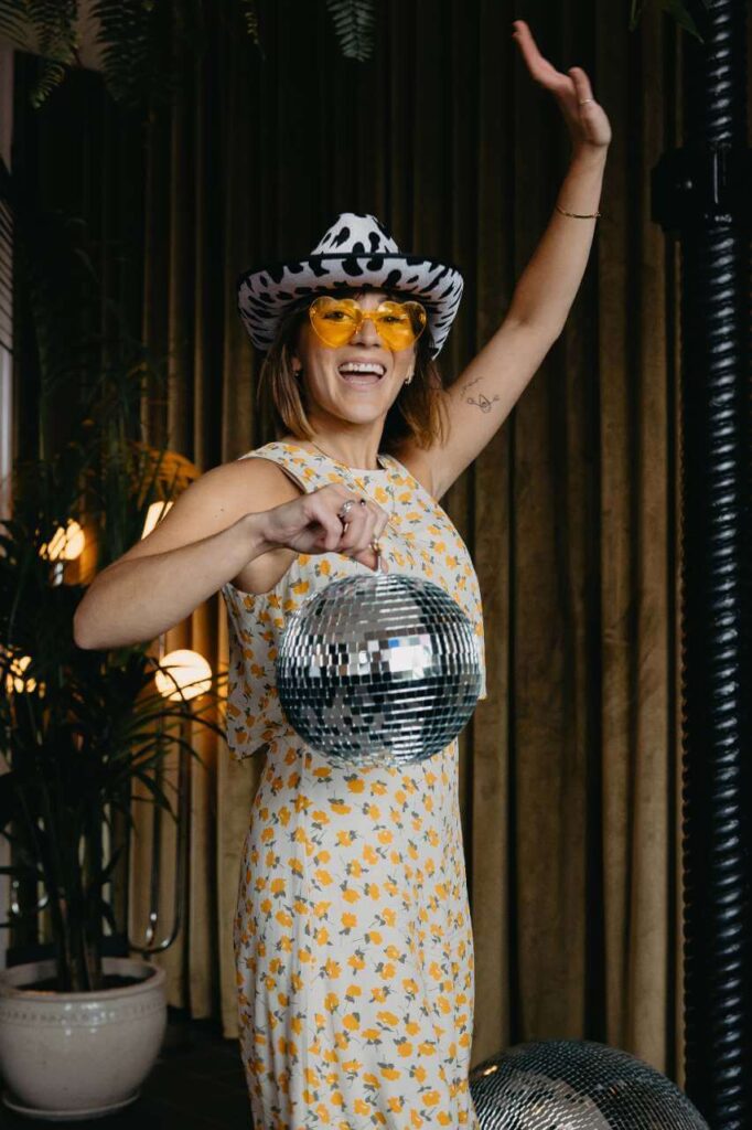 Meleah Richards of lovegood images with disco ball yellow sunglasses and cowprint hat