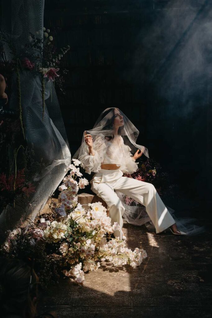 bride with veil in stream of light surrounded by flowers