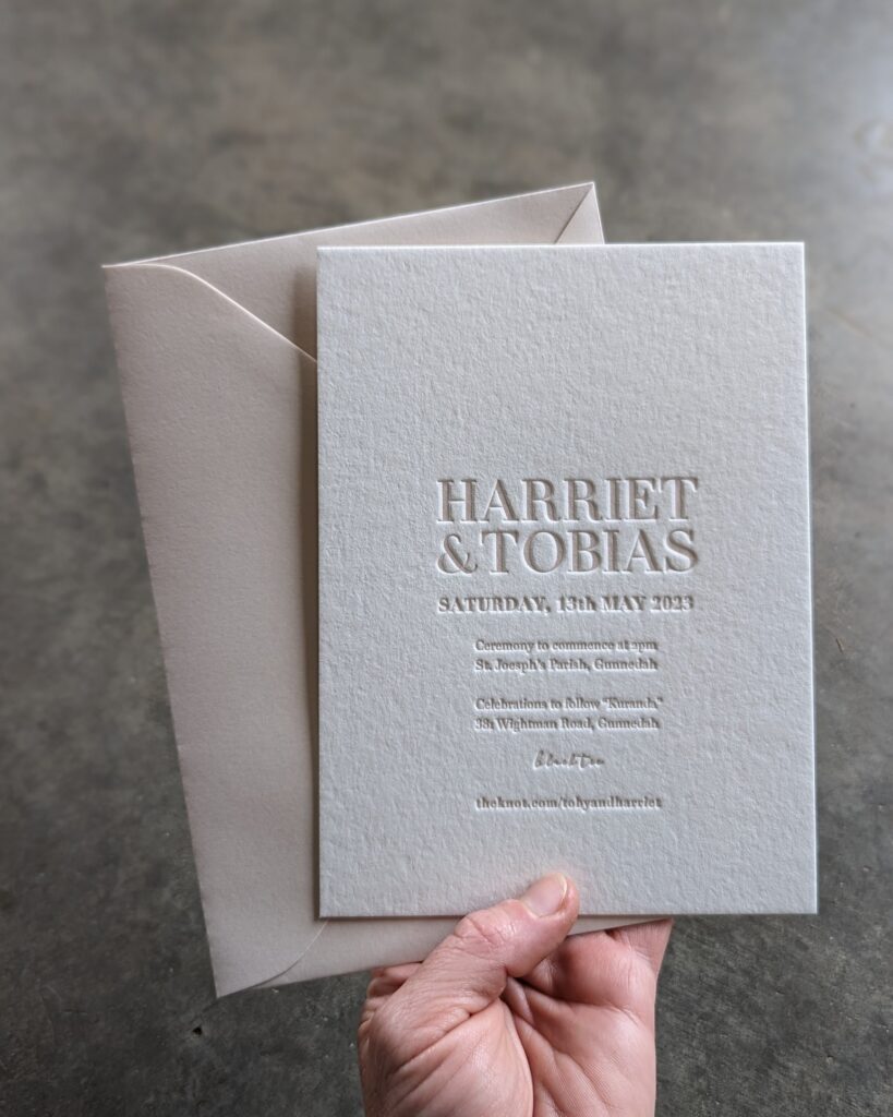 A couple’s wedding invitations printed on white paper.