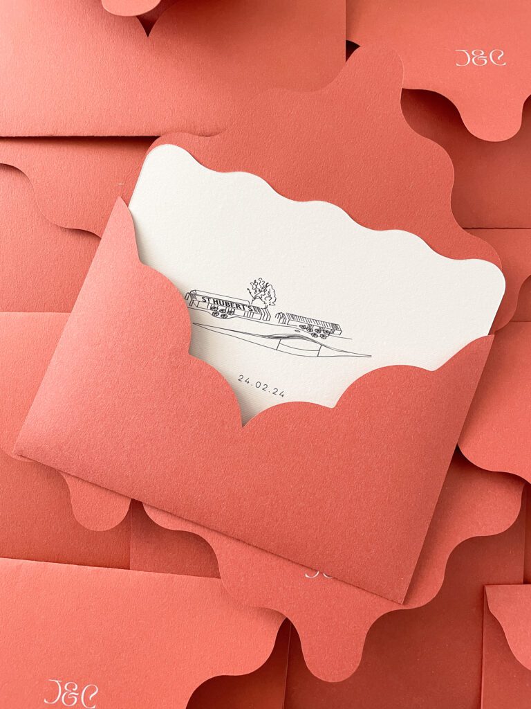 A wedding invitation lying amongst a sea of terracotta envelopes.