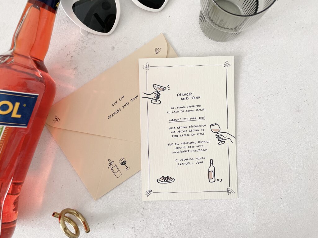 A wedding invitation lying next to a bottle of Aperol.