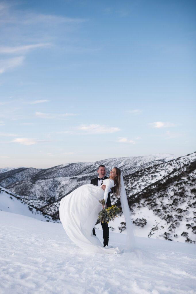 Groom holding bride in snow