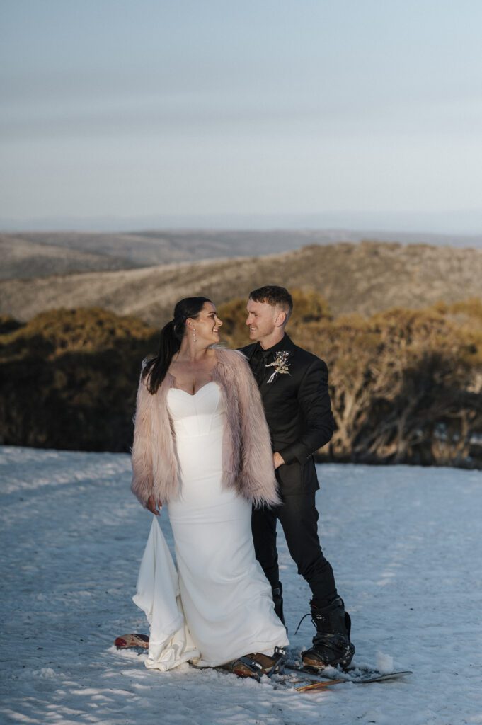 Couple at snow getting married on a snow board